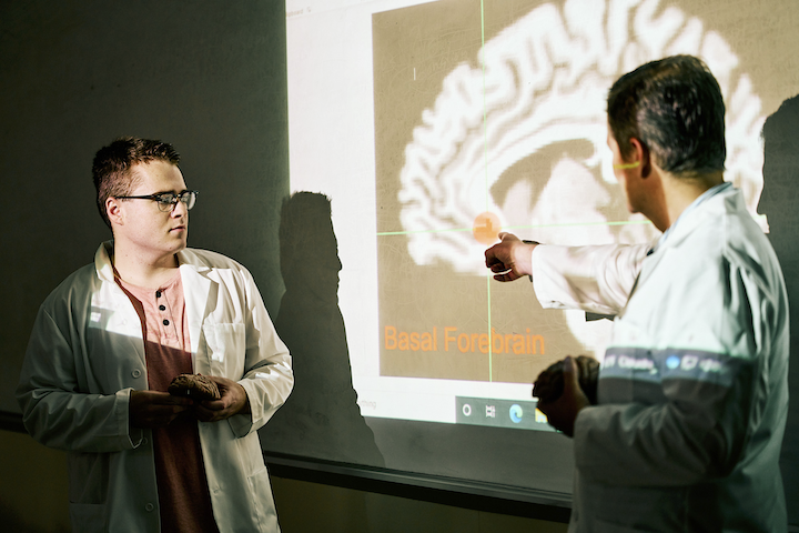 John McCoy,  (Co-PI, VA SRP) pointing to a brain image with Christopher Dennehy, an undergraduate intern